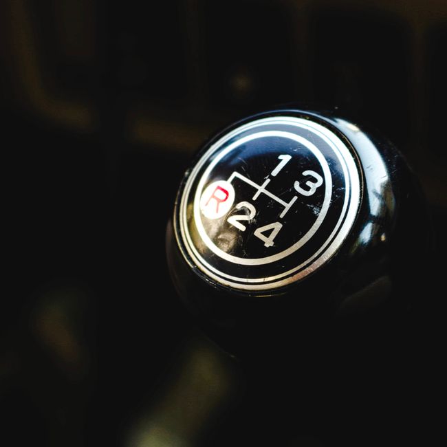 Detailed view of a manual gear shift knob inside a vehicle, focusing on the gear pattern.